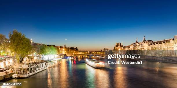 france, paris, pont du carrousel with tourist boats at night - place du louvre stock pictures, royalty-free photos & images