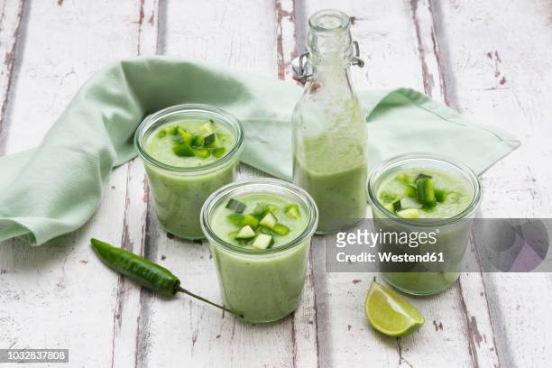 three glasses and a bottle of homemade green gazpacho - gazpacho stock pictures, royalty-free photos & images