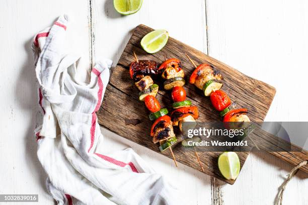 grill skewers with grilled chicken, tomato, bell pepper and zucchini on chopping board - pinchito fotografías e imágenes de stock