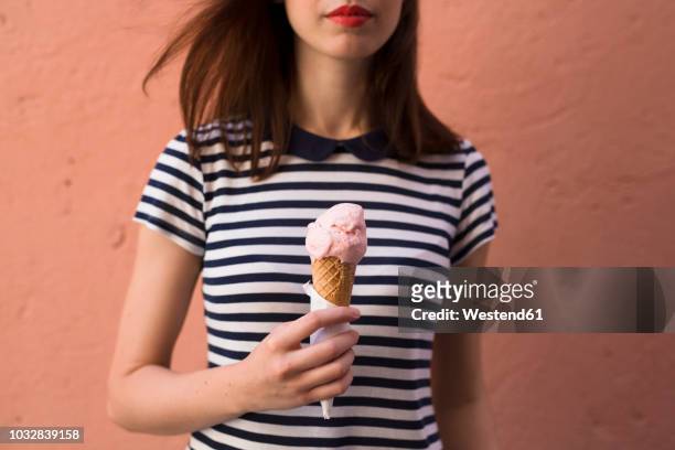 young woman holding ice cream cone with one scoop, partial view - woman ice cream stock pictures, royalty-free photos & images