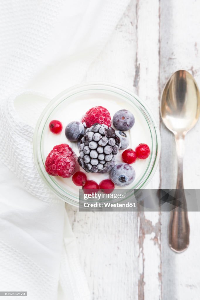 Glass of Greek yogurt with frozen berries