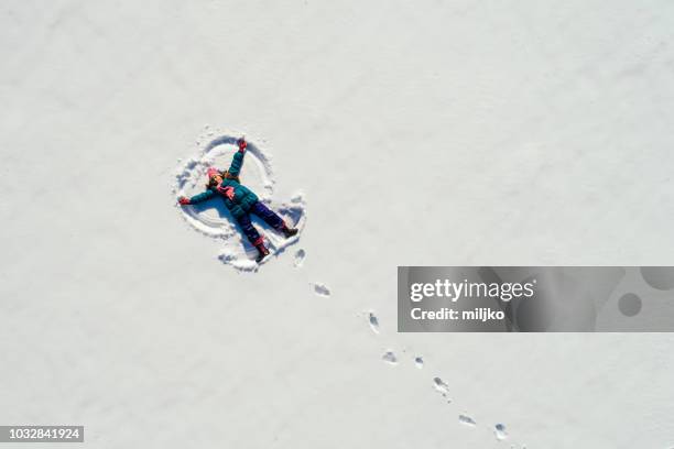 girl making snow angel - snow directly above stock pictures, royalty-free photos & images