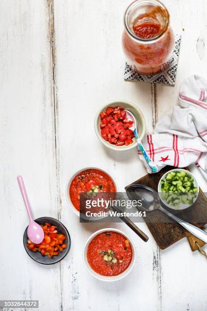 two bowls of gazpacho and bowls of toppings - vegetable soup stockfoto's en -beelden