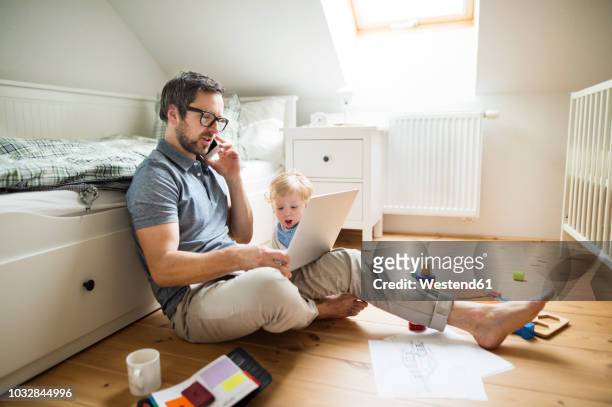 father with his little son working from home - multitasking parent stock pictures, royalty-free photos & images