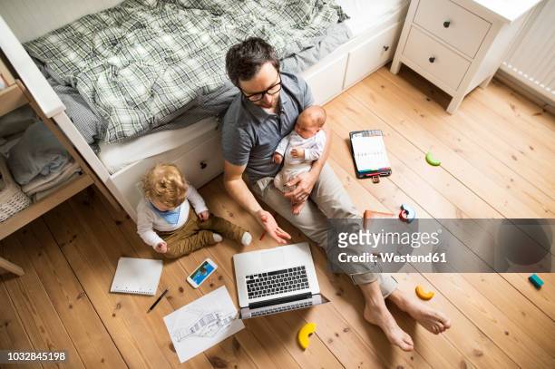 father with his little son and baby daughter working from home - child labor fotografías e imágenes de stock