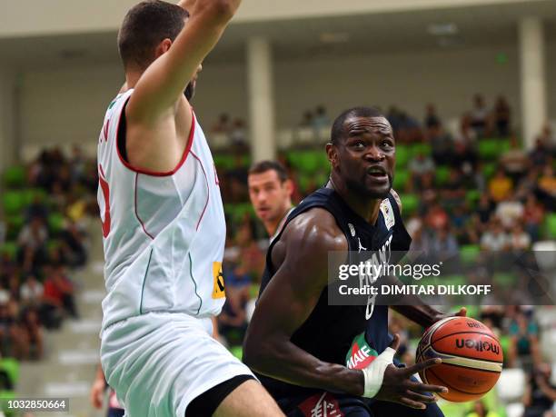 France's Charles Kahudi fights for the ball with Bulgaria's Pavel Marinov during the 2019 FIBA European qualifying basketball match between Bulgaria...