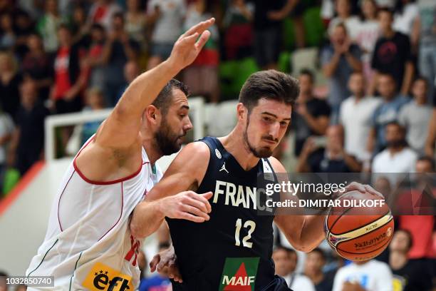 France's Nando De Colo fights for the ball with Bulgaria's Pavel Marinov during the 2019 FIBA European qualifying basketball match between Bulgaria...