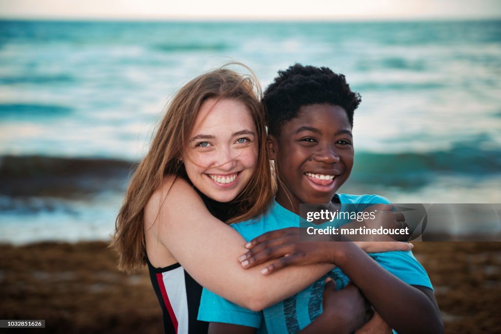 Junge Frau mit preteen Jungen Spaß am Strand in der Abenddämmerung