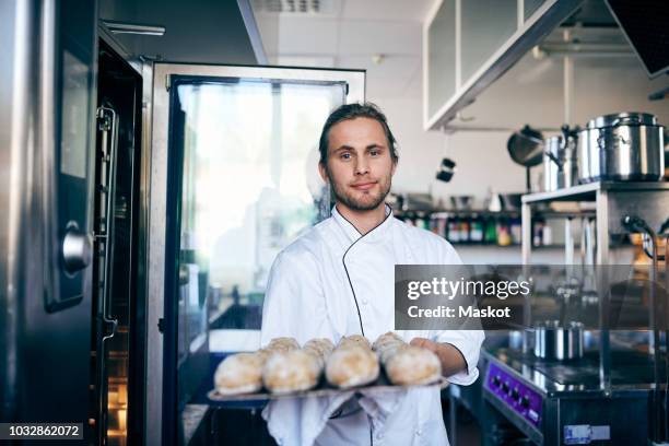 portrait of chef baking breads in commercial kitchen - young chefs cooking stock pictures, royalty-free photos & images