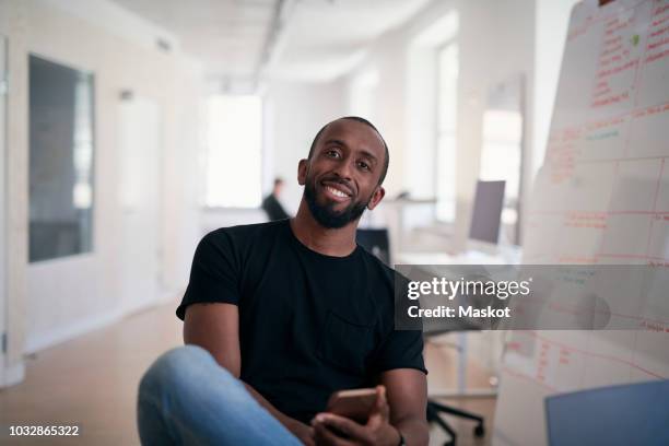 portrait of confident male engineer sitting in office - entertainment occupation stockfoto's en -beelden