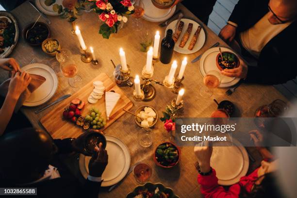 directly above shot of friends enjoying food at dinner party - candle overhead stock-fotos und bilder