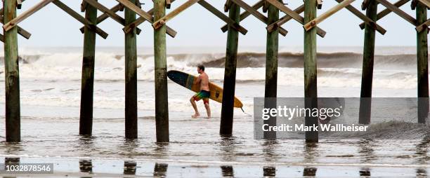 Mike Martin rides the waves at Folly Beach September 13, 2018 in Charleston, South Carolina, United States. Coastal cities in North Carolina, South...