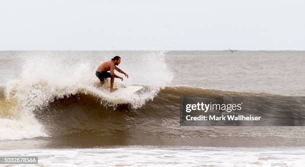 Surfer catches a ride at Folly Beach September 13, 2018 in Charleston, South Carolina, United States. Coastal cities in North Carolina, South...