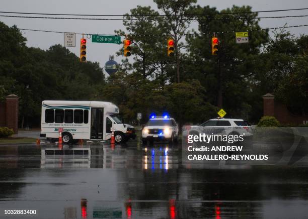 Police block a road as rain from Hurricane Florence falls in Wilmington, North Carolina on September 13, 2018. Hurricane Florence edged closer to the...