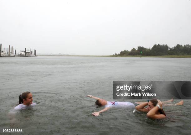Carson Grace Toomer, Martin-Maine Wrangel, and Elizabeth Claire Toomer, swim in the Intracoastal Waterway as Hurricane Florence approaches the area,...