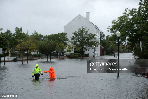 Residents walk in flooded streets as the Neuse River floods its banks during Hurricane Florence September 13, 2018 in New Bern, North Carolina....