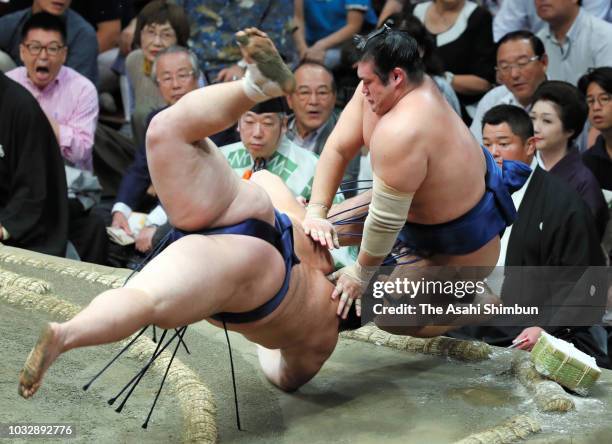 Asanoyama pushes Chiyonokuni out of the ring to win on day five of the Grand Sumo Autumn Tournament at Ryogoku Kokugikan on September 13, 2018 in...