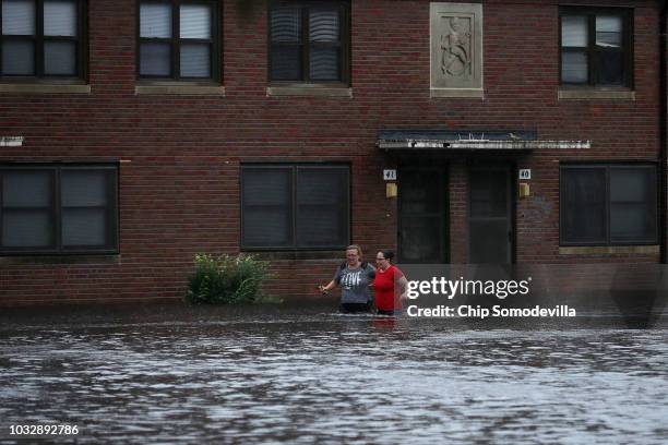 Residents wade through deep floodwater to retrieve belongings from the Trent Court public housing apartments after the Neuse River went over its...