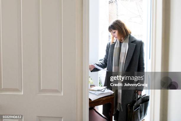 businesswoman standing in hallway and opening mail - study hall stock pictures, royalty-free photos & images