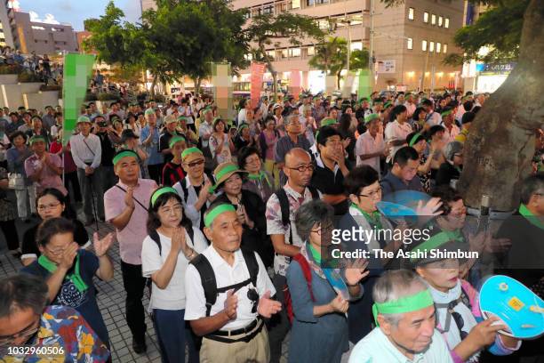 Supporters of opposition 'All Okinawa' movement backed candidate Denny Tamaki listen to a street speech in front of the Okinawa Prefecture...