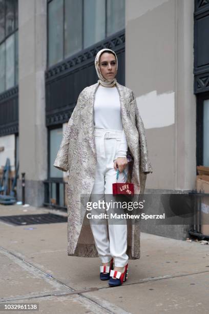 Mademoiselle Meme is seen on the street attending New York Fashion Week SS19 wearing long silver coat with white outfit and red 'Love Me' bag with...