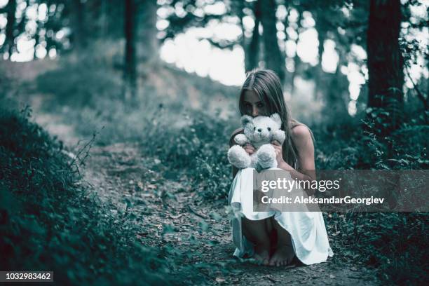 暗い森でテディベア スタンドア ローンで不気味な少女 - zombie girl ストックフォトと画像