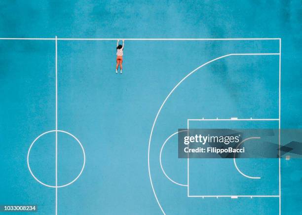 aerial view of a girl hanging in a basketball court - girl lying down stock pictures, royalty-free photos & images