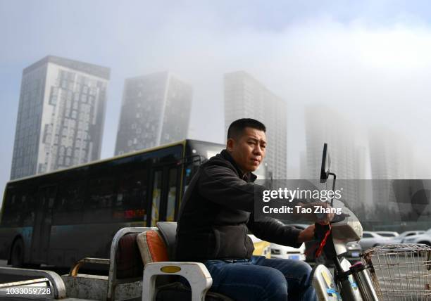 Man rides his motorbike at the Changjiang street during dense fog enveloping Harbin on September 14, 2018 in Harbin, China. The meteorological...