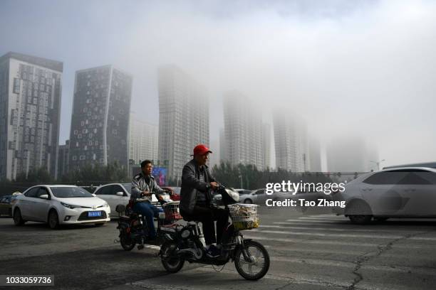 Man rides his motorbike at the Changjiang street during dense fog enveloping Harbin on September 14, 2018 in Harbin, China. The meteorological...