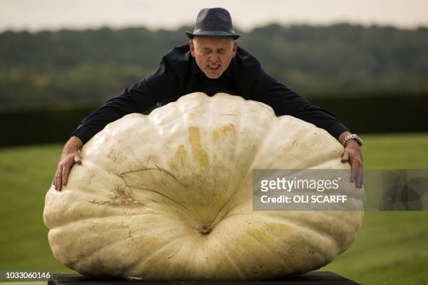 Graham Barrat poses for a photograph with his 319.8 kg pumpkin which won the the heaviest pumpkin competition on the first day of the Harrogate...