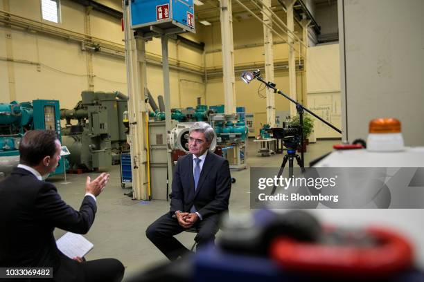 Joe Kaeser, chief executive officer of Siemens AG, listens during a Bloomberg Television interview on the factory floor at the Siemens switchgear...