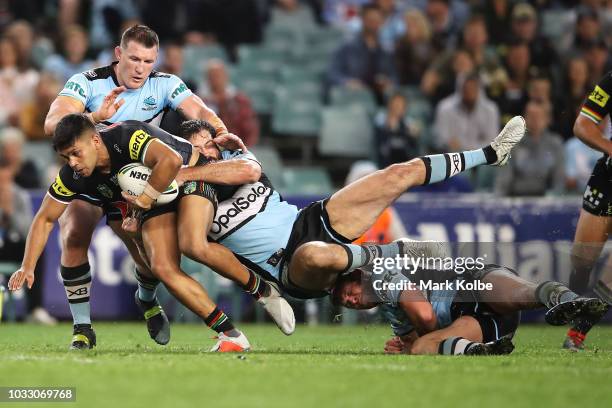 Tyrone Peachey of the Panthers is tackled by Paul Gallen and Aaron Woods of the Sharks during the NRL Semi Final match between the Cronulla Sharks...