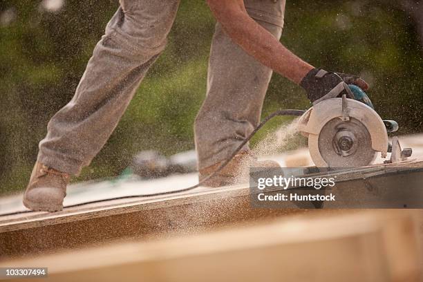 carpenter sawing a board - circular saw stock pictures, royalty-free photos & images