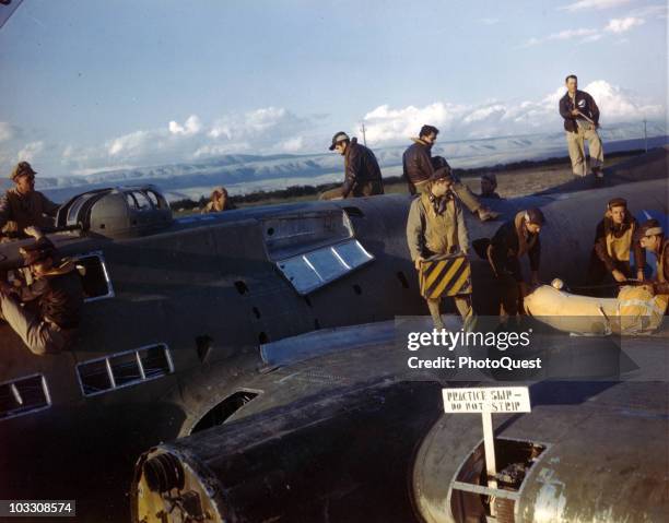 View of future B-17 crew members as they practice procedures for ditching their aircraft, 1944. Note the missing propeller and the sign that reads...