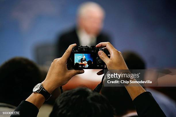 Reporter makes a photograph of Secretary of Defense Robert Gates as he announces a plan to close a Joint Forces Command in Norfolk, Virginia, as part...