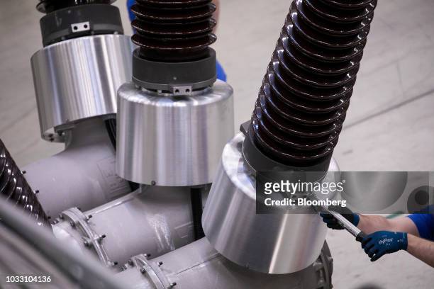 An employee assembles dead tank circuit breaker brushings on the production line inside Siemens AG switchgear electronic power unit factory in...