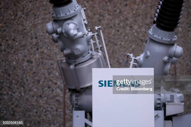 Siemens company logo sits on a sign in front of a dead tank circuit breaker outside the Siemens AG switchgear electronic power unit factory in...