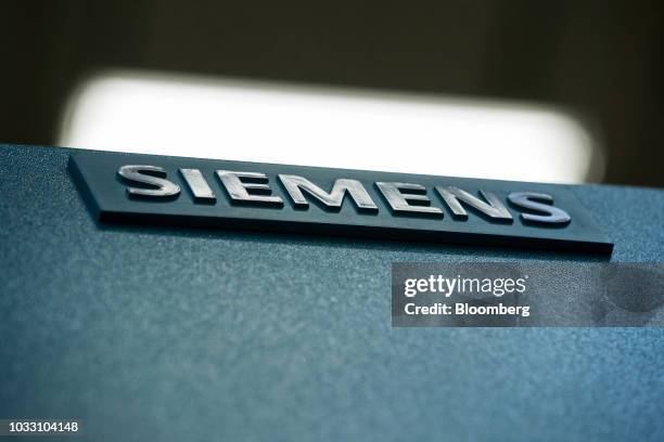 Siemens company logo sits on a sign inside the Siemens AG switchgear electronic power unit factory in Berlin, Germany, on Thursday, Sept. 13, 2018....