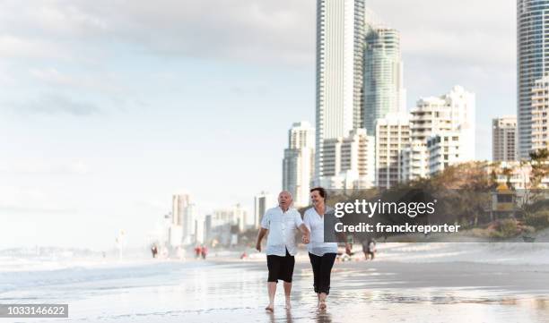 happiness senior couple running happiness in the city beach - gold coast australia stock pictures, royalty-free photos & images