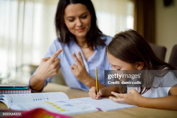 madre ayudando a su hija con la tarea - simbolos matematicos fotografías e imágenes de stock