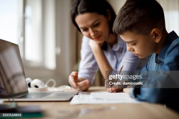 mor att hjälpa tonåringen med läxor - homework bildbanksfoton och bilder