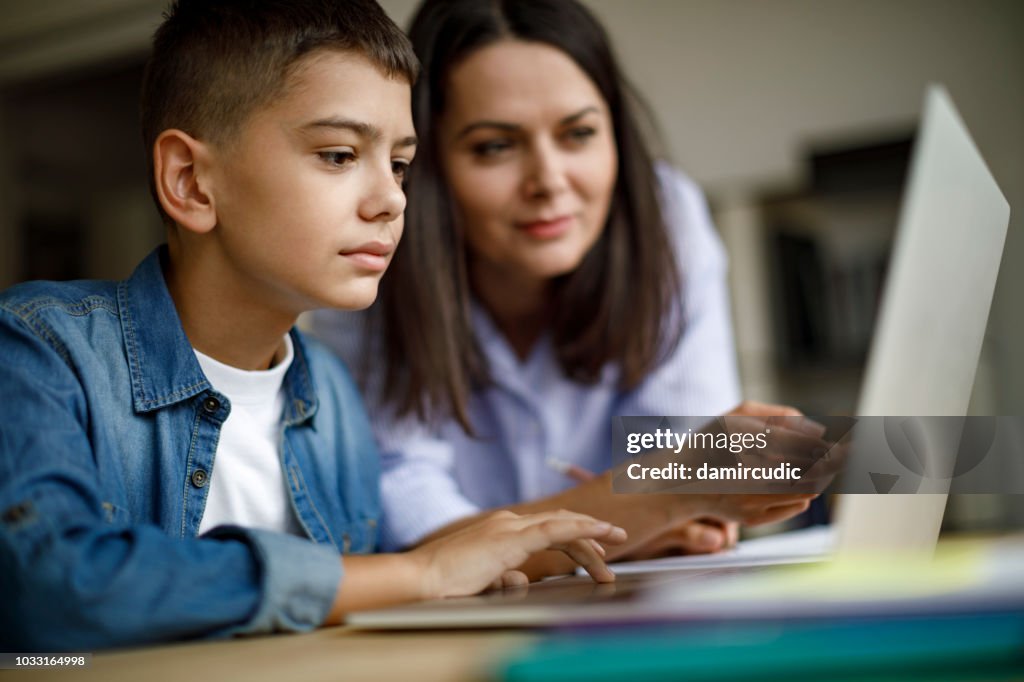 Mother an son using laptop at home