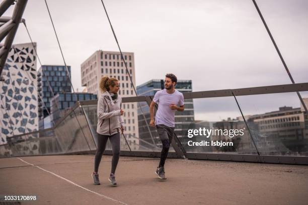 beautiful couple training together at sunset in down town. - oslo train stock pictures, royalty-free photos & images