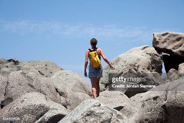 a woman hiking along a rocky coastline. - puerto vallarta fotografías e imágenes de stock