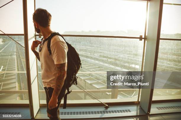 getatoeëerde jongeman reiziger - airport hipster travel stockfoto's en -beelden