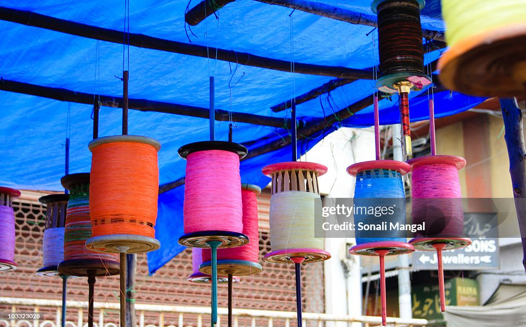 Spindles with kite threads hanging in a shop