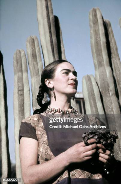 Artist Frida Kahlo poses for a portrait at the home and studio she shares with her husband Diego Rivera, designed by architect Juan O'Gorman circa...