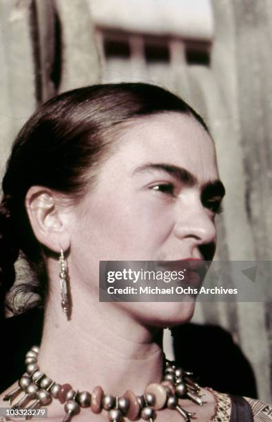 Artist Frida Kahlo poses for a portrait at the home and studio she shares with her husband Diego Rivera, designed by architect Juan O'Gorman circa...