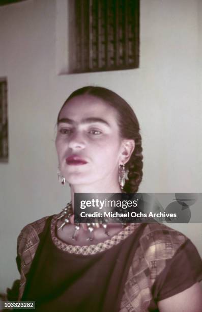 Artist Frida Kahlo poses for a portrait at the home and studio she shares with her husband Diego Rivera, designed by architect Juan O'Gorman circa...