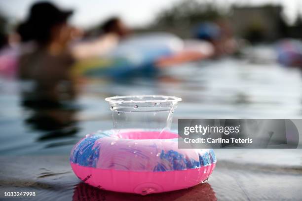 empty plastic cup in an inflatable pool float at a pool party - float imagens e fotografias de stock